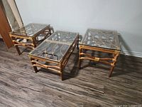 Three bamboo and glass tables set on floor