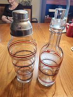 Front view of glass cocktail shaker and decanter showing striped decoration