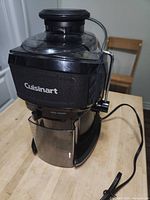 Juicer fully assembled showing brand logo, locking arm and cord