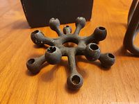 Black multi-arm candle holder showing ten taper sockets