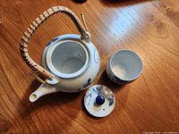Top view of open teapot showing interior, lid, and cup