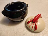Black glazed pot body and ivory lid with red lobster handle