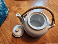 Top view of open ceramic teapot showing interior and lid