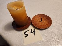 Pillar candle on one plate beside second plate with spike visible