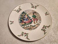 Front view of plate showing central scene, holly border and gold rim