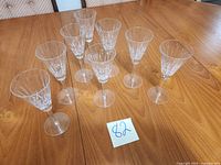 Eight crystal V-shaped wine glasses standing on table