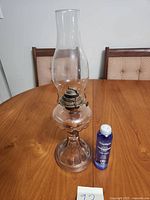 Full view of lamp with chimney and oil bottle for scale