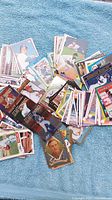 Wide view of scattered baseball cards from various brands on blue background