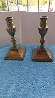 Both brass candlestick holders front view on blue cloth