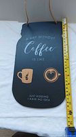 Full view of mason jar-shaped coffee wall plaque with tape measure showing height