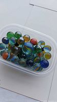 Top view of marbles showing variety of colors and container
