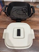 Pan base, lid, wire rack and power probe visible