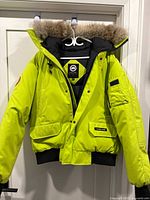 Front view of neon yellow Canada Goose jacket on hanger