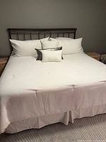 King bed frame with bedding and metal headboard