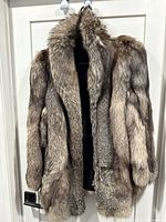 Front view of silver-grey fox fur coat hanging on door