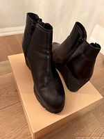 Boots angled on box showing outer sides and wedge heels