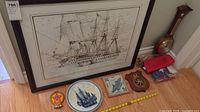 Overall lot including framed ship art, ceramic pieces, plaques, barometer, flags