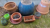Group of assorted planters, saucers, bottle