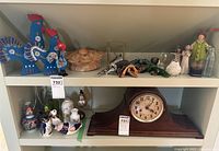 Top shelf view showing porcelain and glass figurines, clock below excluded