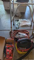 Lot overview showing walker, vacuum, extension cords, wrench set, handsaw