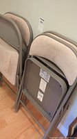 Four folded chairs showing frames and upholstery