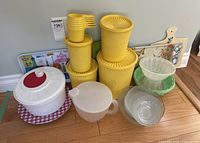 Group shot of all items: Tupperware canisters, stacking cups, bowls, tray, cutting board