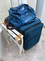 Overall view showing duffel bag, suitcase, luggage rack