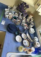 Countertop view showing the full assortment of mugs, bowls, plates, vases and serveware