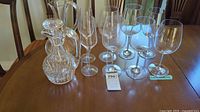 Group shot of two crystal decanters, two champagne flutes and six wine glasses on table