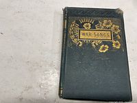 Front cover showing title War Songs and gilt floral design