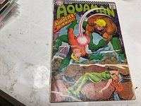 Front cover of Aquaman #34 comic showing artwork and wear