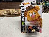 Front view of sealed Hot Wheels The Muppets Fozzie Bear car on card
