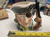 Front view of pirate character mug showing pistol handle and facial details