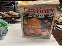 front of boxed Care Bears stand-up cake pan set