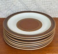 Stack of seven matching Denby stoneware plates showing design and colour