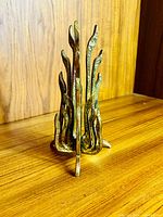 Full view showing flame-like prongs and tripod base