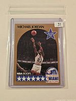 Front view of sleeved 1990 NBA Hoops Michael Jordan All-Star Weekend card showing player image, gold border, All-Star East emblem and Miami 1990 logo