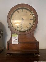 Front view of mahogany drum head mantel clock showing dial, bezel, and overall case design