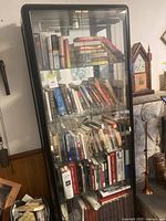 Full view of black-framed glass display cabinet with shelves and books (books not included)