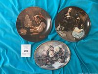 Front view of three collector plates on fabric background