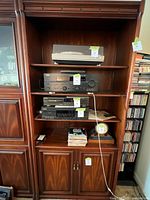 Front view of wooden entertainment shelving unit with shelves and cabinet