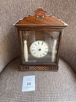 Front view of walnut weight-driven clock showing dial and porcelain columns