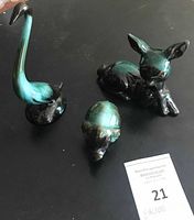 overview of three ceramic figurines on black background