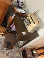 Sewing machine on wooden table, accessories box visible
