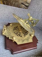 Full view of brass sundial on wood base