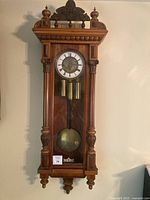 front view of wooden wall pendulum clock
