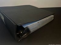 Black binder closed showing thickness of card pages