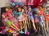 Overview of loose Barbie dolls, accessories grouped at bottom left