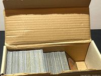 Open cardboard box showing two stacks of Magic: The Gathering cards