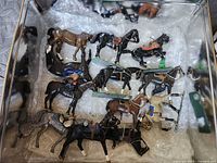 Top-down view of tin showing assortment of model horses cushioned in bubble wrap